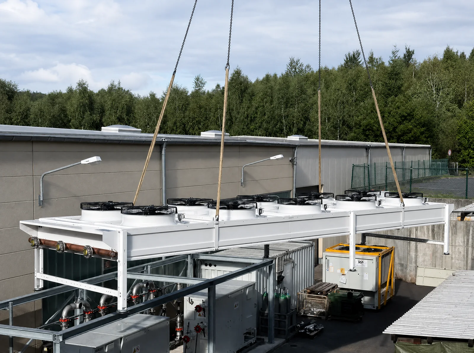 Lifting a recooler by crane onto the steel frame of the propane technical centre at Uponor – outdoor installation