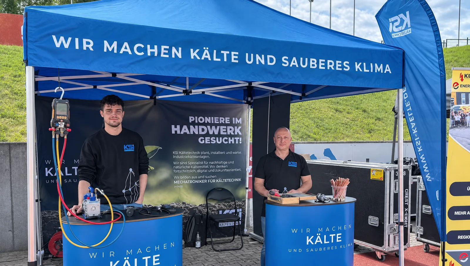 Messestand von KSI Kältetechnik auf der Ausbildungsmesse Vogtland im Vogtlandstadion Plauen – blauer Pavillon mit dem Schriftzug „Wir machen Kälte und sauberes Klima“ an der Laufbahn