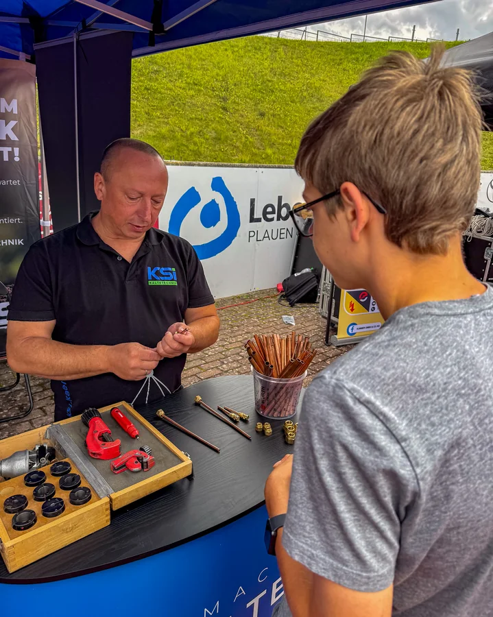 An employee of KSI Kältetechnik explains to a young person in Plauen how to work with copper pipe