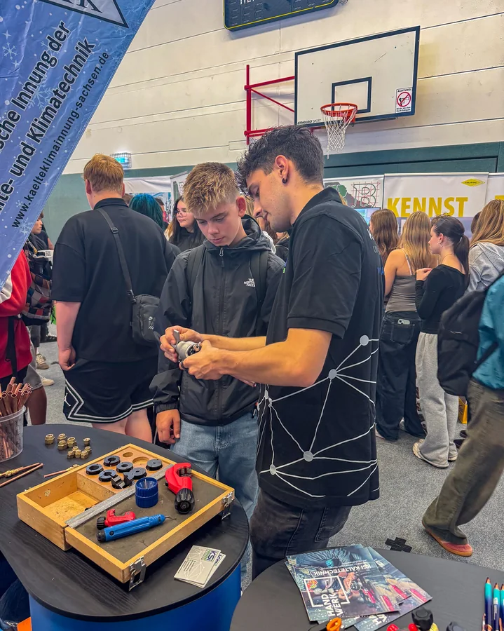 A group of young people are trying out the tool at the stand in Reichenbach
