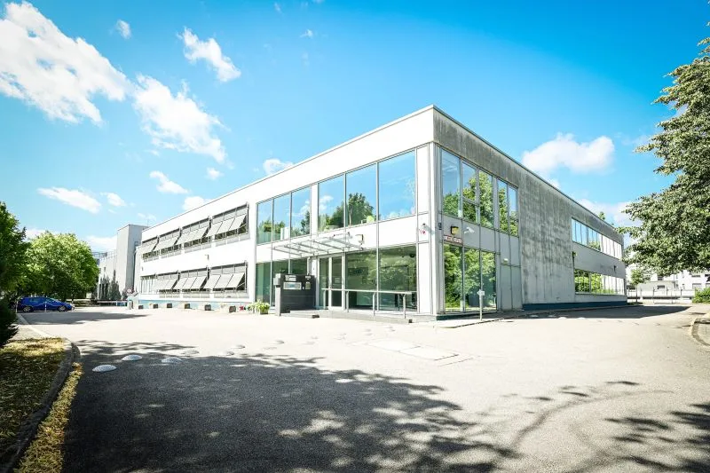 Das NorthC-Rechenzentrum München 2 an der Wamslerstraße im Münchner Osten – weißer Zweigeschosser mit verglaster Gebäudeecke und Glasvordach über dem Eingang